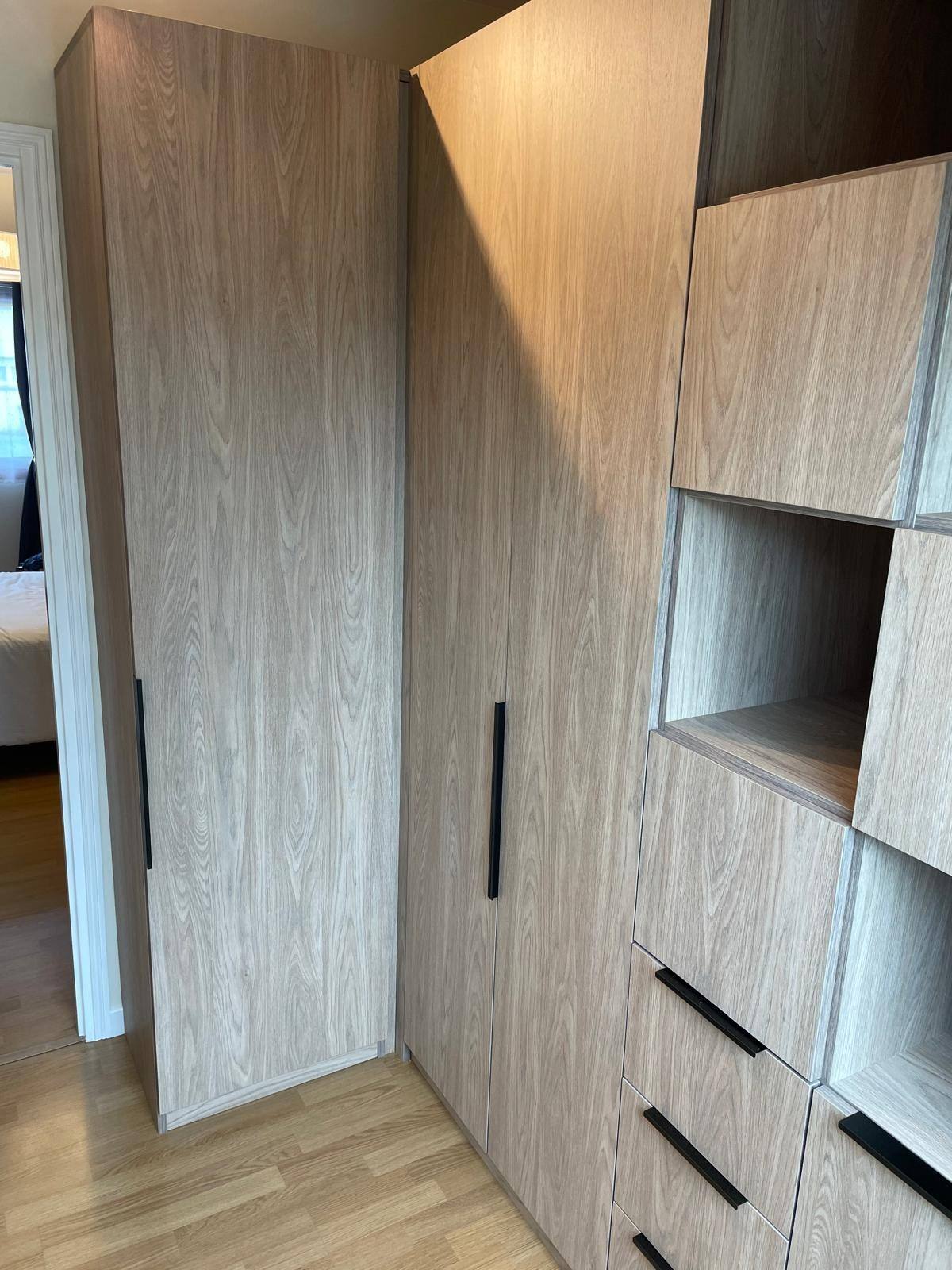 Armoire et rangements en bois clair à poignées noires, sous pente, à Pierrelaye