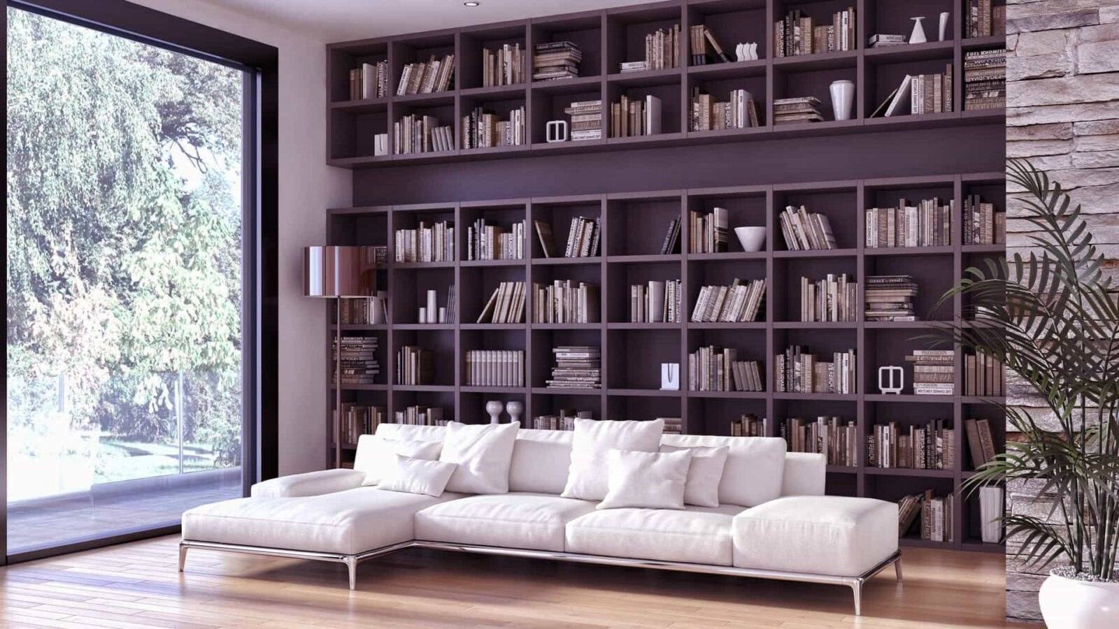 Bibliothèque sur mesure du sol au plafond derrière un canapé blanc, dans un salon