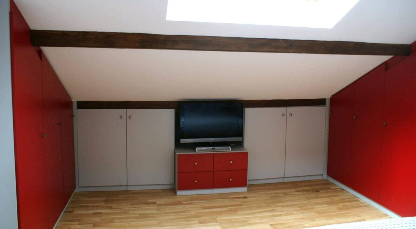 Combles aménagés avec placards rouges et blancs, vue de face