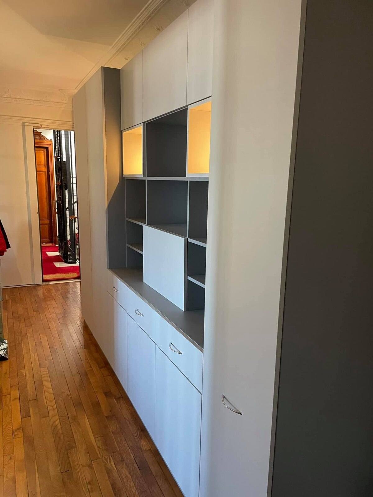 Meuble de couloir gris et blanc avec niches éclairées