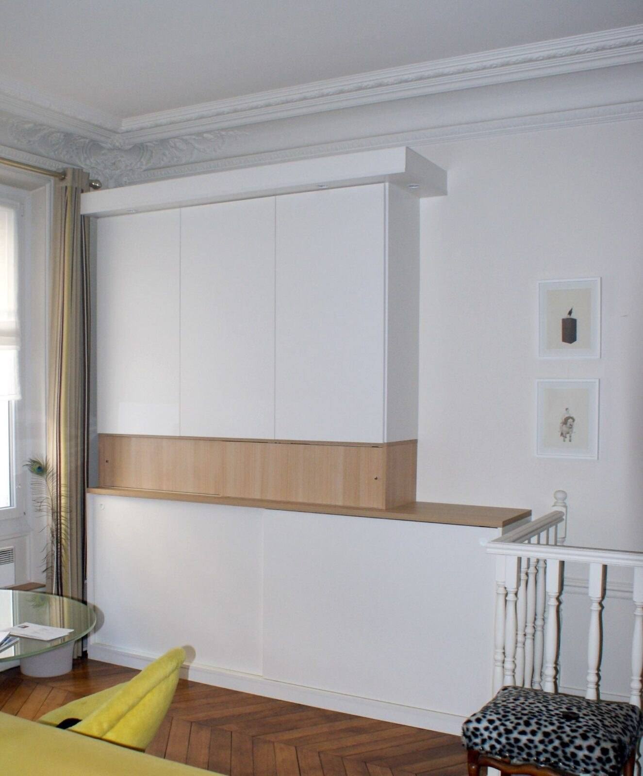 Placards hauts blancs et plan en chêne au-dessus de rangements, dans un salon à moulures