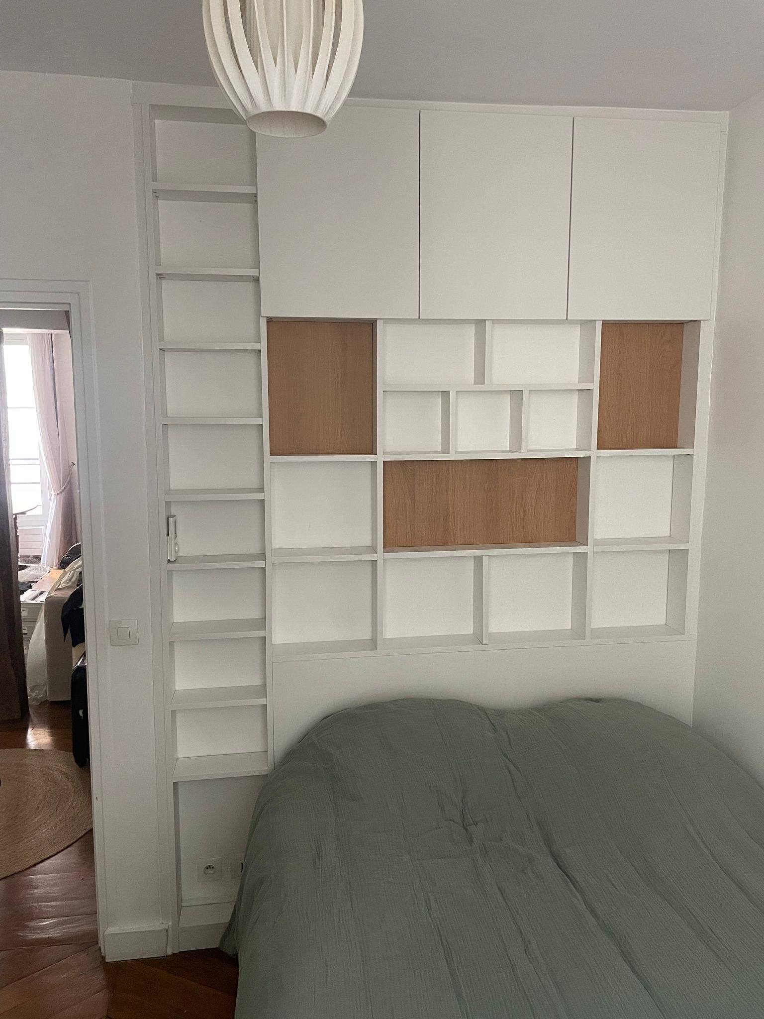 Tête de lit bibliothèque sur mesure à niches blanches et bois, avec placards hauts, à Paris 17e