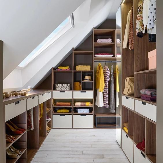 Dressing sur mesure installé sous une pente de toit dans une chambre mansardée